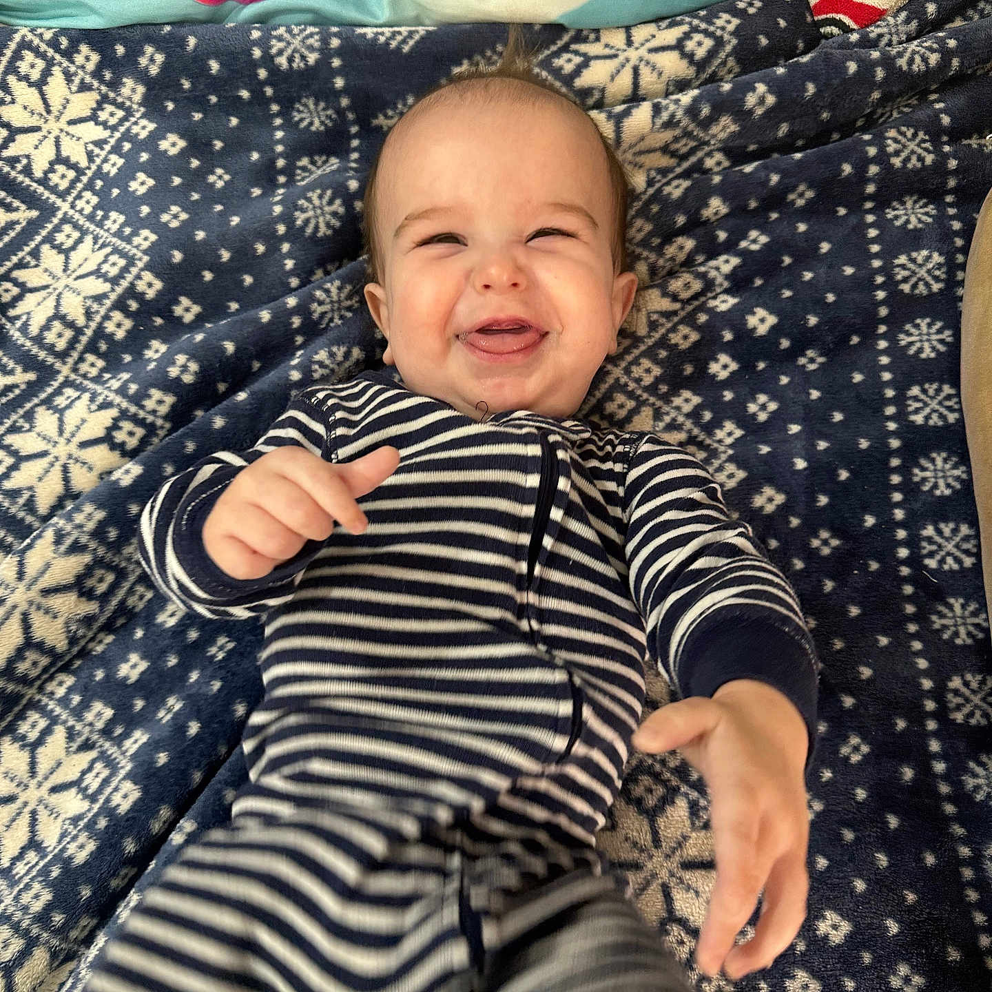 Noah Edwards joined the competition — help win amazing prizes! baby, blanket, child, colorful, cozy, cute, expression, face, hand, happy, indoor, infant, lying_down, pajamas, patterned_blanket, playful, portrait, smiling, striped_pajamas, young_child