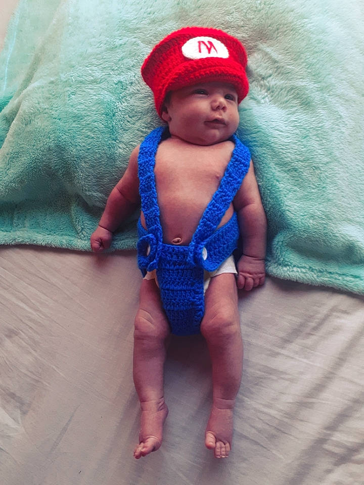 Connor a rejoint le concours — aidez-le/la à gagner de superbes lots ! baby, baby_products, baby_toddler_clothing, cap, child, doll, electric_blue, fashion_accessory, fictional_character, finger, foot, headwear, human_leg, linens, magenta, pattern, person, stuffed_toy, thigh, toddler