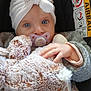 baby, pacifier, stuffed_animal, hat, car_seat, airbag_warning, blue_eyes, hand, clothing, blanket, child, portrait, cute, infant, cozy, soft_toy, indoor, sitting, warm, young_child