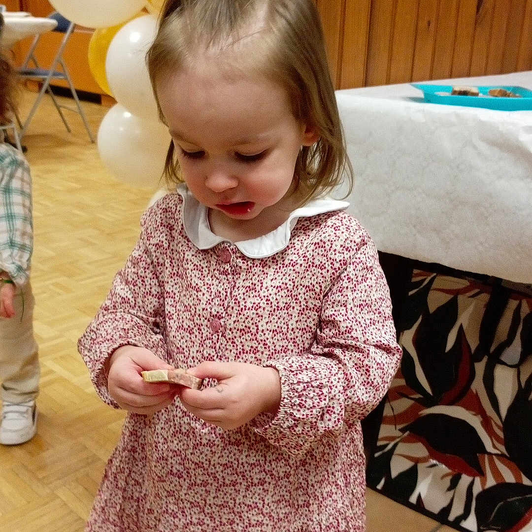 Théa a rejoint le concours — aidez-le/la à gagner de superbes lots ! child, girl, dress, balloons, indoor, party, floor, wood_paneling, table, plate, curious, standing, long_sleeves, collar, young_child, light_brown_hair, footwear, tile_floor, background, event