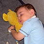 baby, child, sleeping, plush_toy, yellow, pacifier, blue_shirt, denim, bed, blanket, toy, soft, cute, peaceful, indoor, nap, rest, comfort, young_child, infant