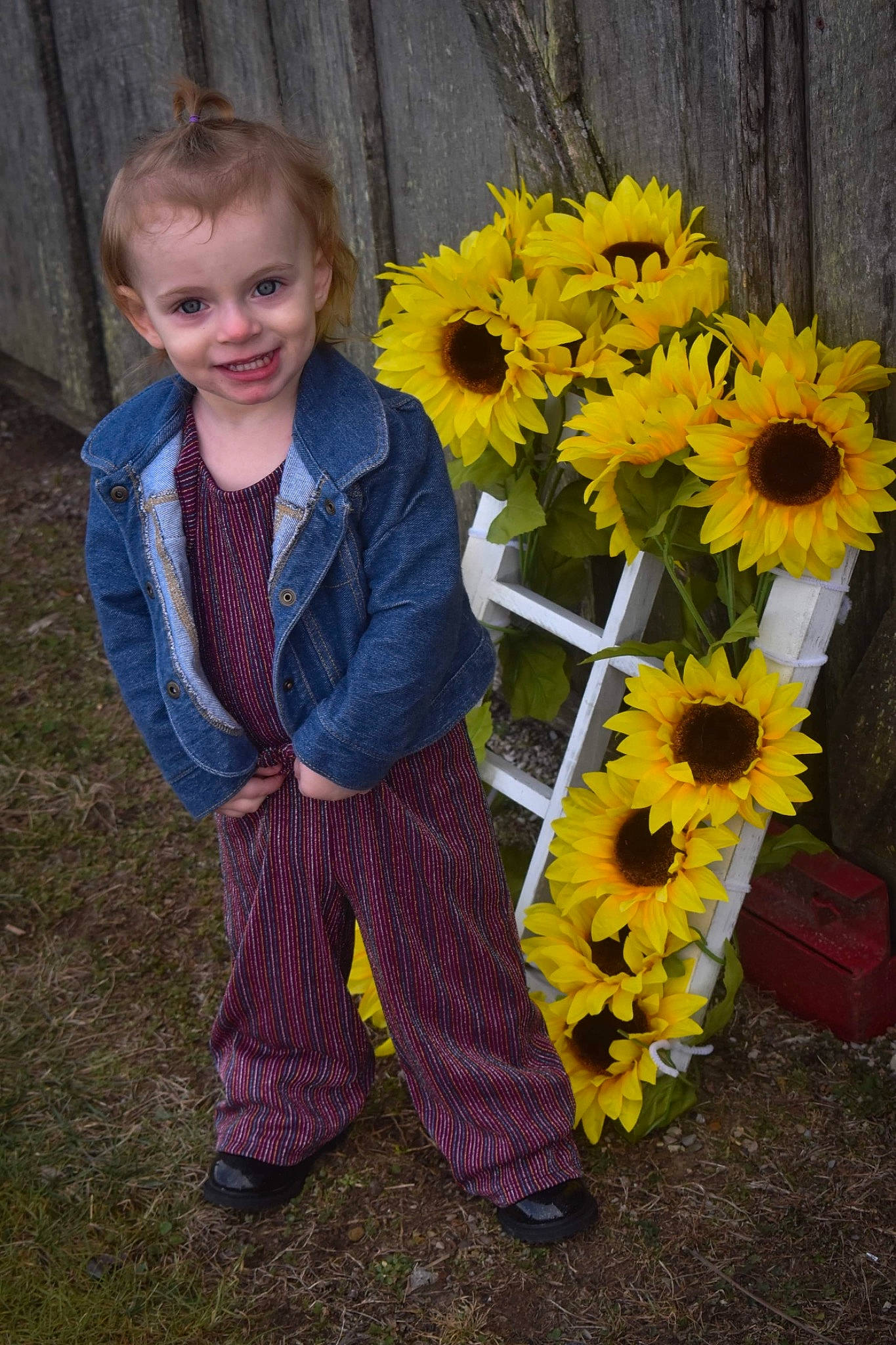 Kyra is registered to the contest to win money with this photo: annual_plant, asterales, baby_toddler_clothing, bouquet, child_model, cut_flowers, daisy_family, floral_design, floristry, flower, flowering_plant, joy, laugh, people_in_nature, person, petal, pollen, purple, sunflower, tongue