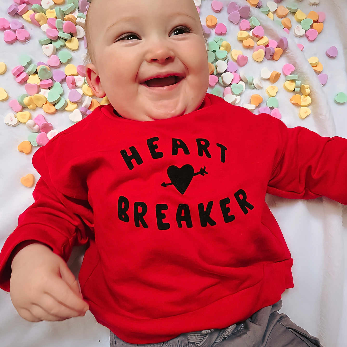 Lennox is registered to the contest to win money with this photo: applique, baby, babylaughing, bodypart, clothing, face, finger, hand, happy, head, knitwear, pants, pattern, person, photography, portrait, smile, sweater, sweatshirt, t_shirt