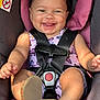 baby, car_seat, child, smiling, happy, infant, seat_belt, purple, butterfly_print, sandals, cute, close_up, face, skin, straps, safety, young, cheerful, portrait, indoors