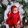 Solana joined the competition — help win amazing prizes! baby, infant, red_dress, headband, blanket, christmas_wreath, greenery, silver_ornaments, ribbon, hand, festive, holiday, cozy, smiling, lying_down, indoors, cute, celebration, decoration, soft