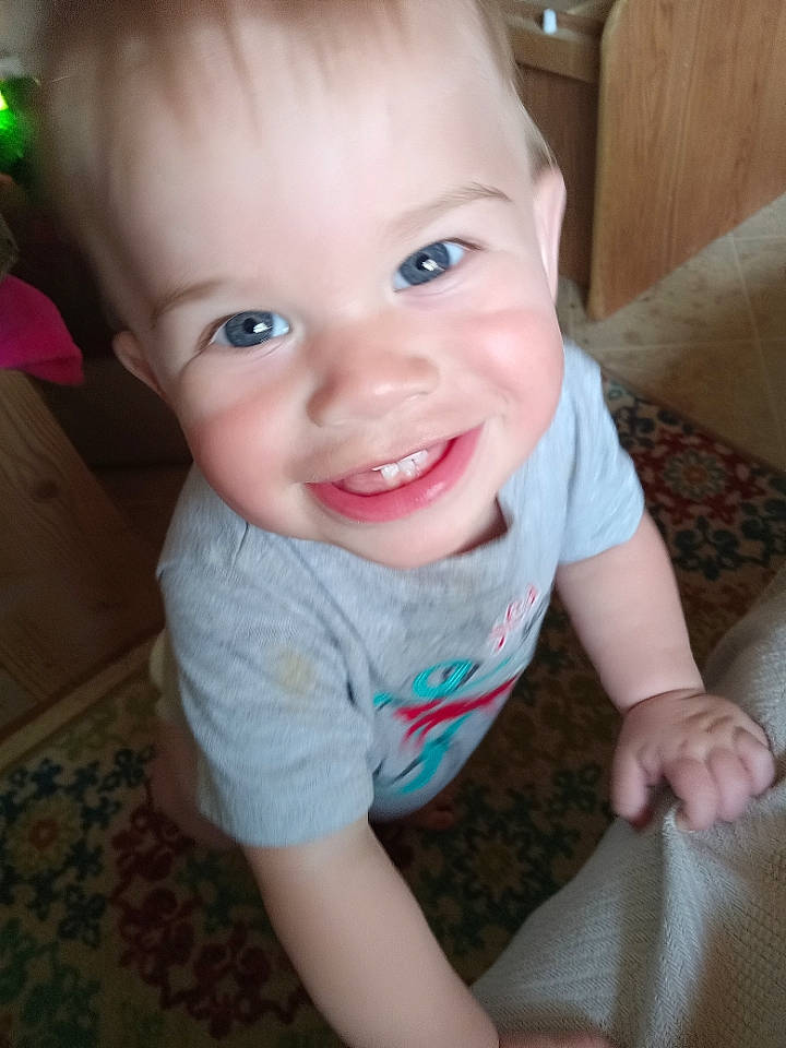 Blade is registered to the contest to win money with this photo: arm, baby, baby_toddler_clothing, cheek, chin, eyelash, finger, floor, flooring, happy, head, iris, joy, lip, mouth, nose, person, skin, sleeve, smile