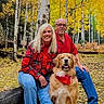 golden_retriever, dog, couple, people, portrait, outdoor, forest, aspen_trees, autumn, fall_colors, yellow_leaves, nature, smiling, sitting, pet, family, red_flannel, blue_jeans, woodland, outdoor_photography