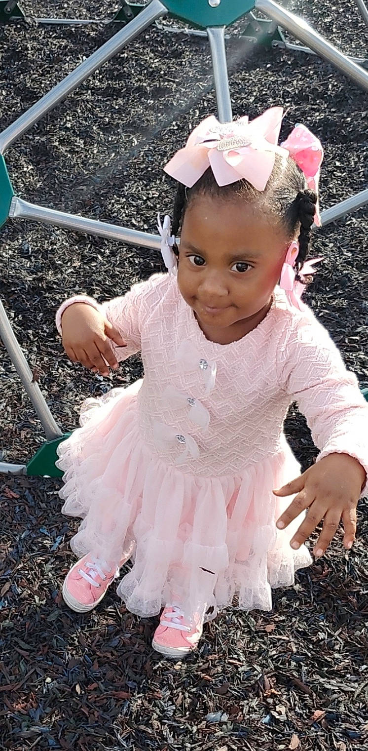 Taeanna joined the competition — help win amazing prizes! baby, baby_toddler_clothing, child, face, facial_expression, fashion_accessory, fun, grass, happy, headband, headgear, headpiece, jewellery, magenta, people_in_nature, person, pink, purple, sleeve, smile