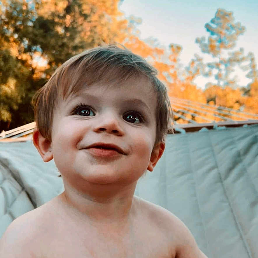 Whitley is registered to the contest to win money with this photo: background, bare_chested, child, cute, daylight, expression, face, hair, happy, head, innocent, nature, outdoor, portrait, skin, sky, smiling, toddler, tree, young