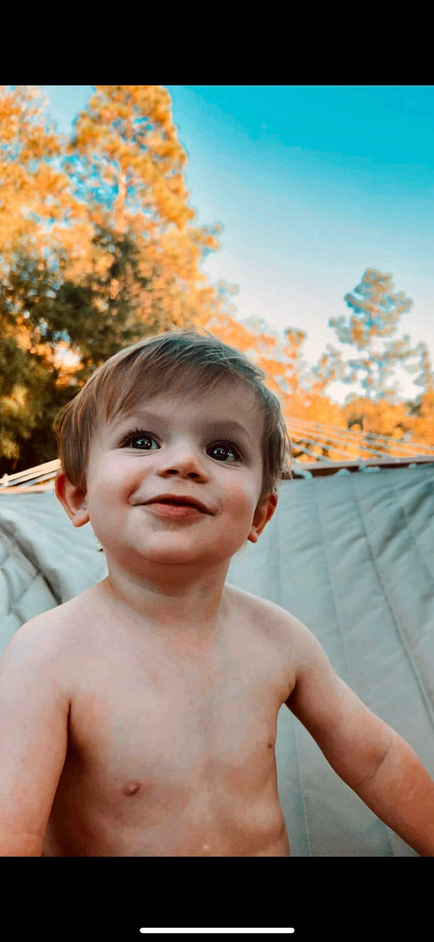 Whitley is registered to the contest to win money with this photo: child, toddler, smiling, outdoor, nature, tree, sky, daylight, bare_chested, cute, face, portrait, young, happy, skin, expression, innocent, head, hair, background