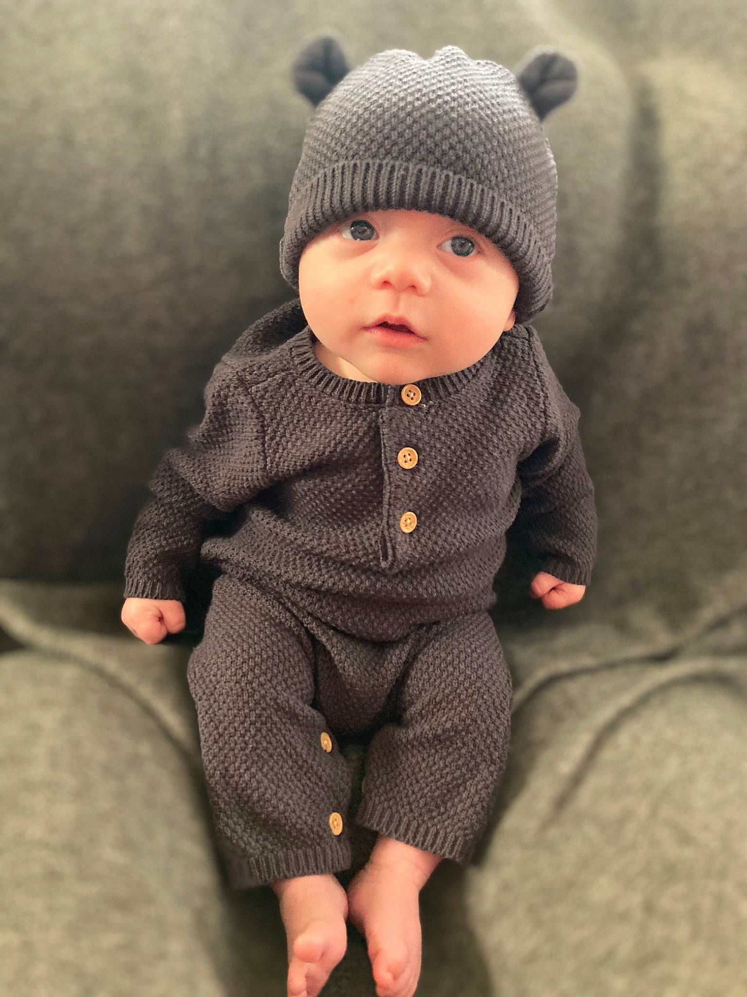 Aurelius is registered to the contest to win money with this photo: baby, baby_toddler_clothing, beanie, cap, cheek, child, collar, eye, face, grey, head, headwear, jacket, knit_cap, outerwear, pattern, person, sitting, sleeve, toddler