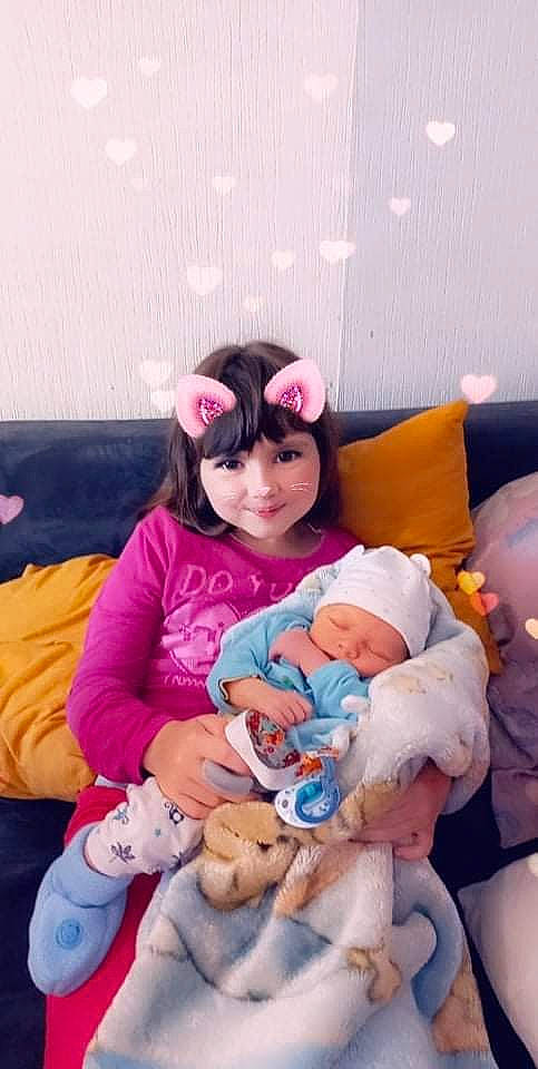 Ninon participe au concours pour gagner de l'argent avec cette photo : baby, child, comfort, couch, event, fun, happy, headwear, holiday, joy, lap, magenta, person, pink, plush, purple, room, sitting, smile, stuffed_toy