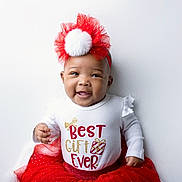 A'Layah is registered to the contest to win money with this photo: baby, child, smiling, headband, pom_pom, white_shirt, red_skirt, festive_clothing, holiday, cute, portrait, indoor, happy, infant, toddler, celebration, gift, accessory, person, studio_lighting