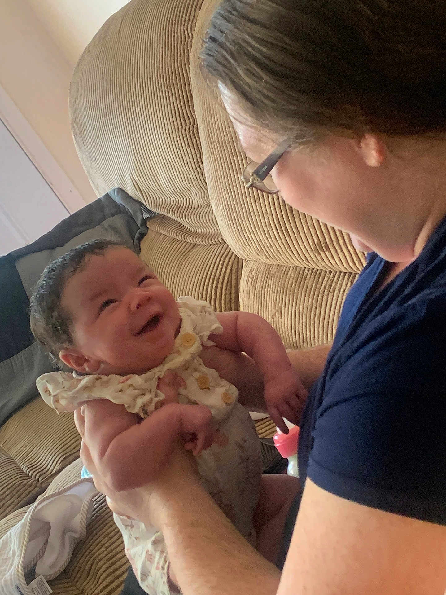 Xophia is registered to the contest to win money with this photo: adult, baby, closeup, clothing, couch, face, glasses, happy, holding, home, indoor, infant, interaction, joy, love, person, portrait, sitting, skin, smile