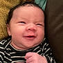 baby, infant, smiling, face, hands, striped_clothing, blanket, texture, cozy, closeup, cute, young_child, expression, skin, person, indoor, portrait, newborn, happy, fist