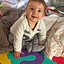 baby, infant, smiling, play_mat, foam_puzzle, blanket, bedding, onesie, sitting, crawling, happy, big_eyes, toy, nursery, hand, face, indoor, playtime, colorful, cute