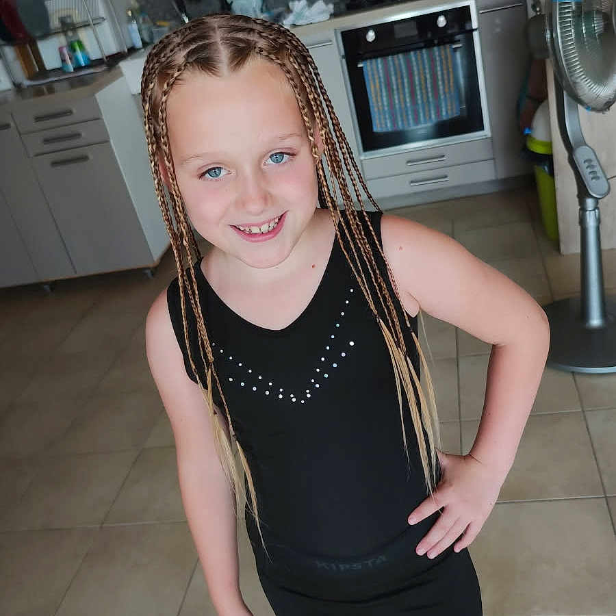 Mathéa participe au concours pour gagner de l'argent avec cette photo : appliances, black_clothing, braids, cabinet, casual, child, countertop, fan, floor_tiles, girl, happy, indoor, kitchen, modern_kitchen, oven, person, pose, smile, standing, youth