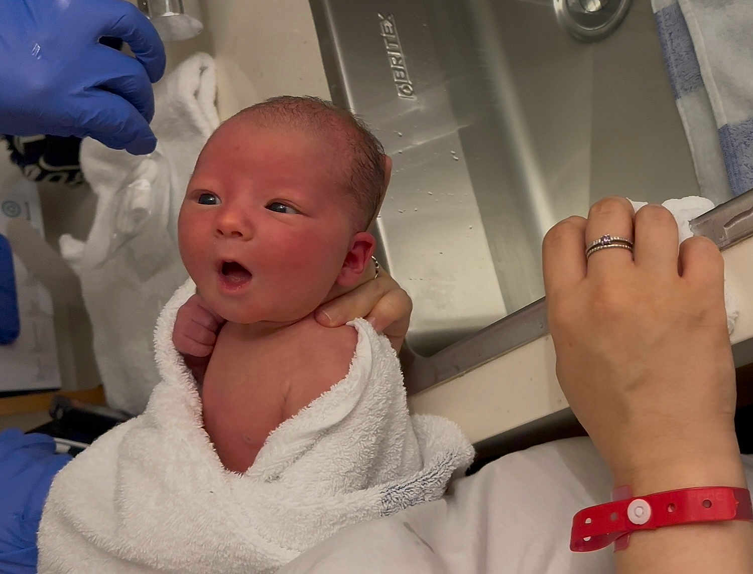 Leo joined the competition — help win amazing prizes! newborn, baby, towel, bath, hand, ring, hospital_wristband, sink, bathroom, person, skin, face, expression, glove, blue_glove, water, fresh, wrapped, holding, cute