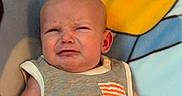 Waylon joined the competition — help win amazing prizes! arm, baby, blanket, cartoon, child, clothing, cute, emotion, expression, face, grumpy, hand, indoors, infant, onesie, portrait, sitting, skin, toddler, young
