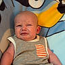 arm, baby, blanket, cartoon, child, clothing, cute, emotion, expression, face, grumpy, hand, indoors, infant, onesie, portrait, sitting, skin, toddler, young