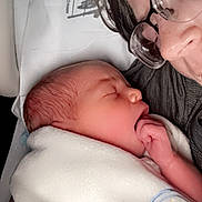 Waylon is registered to the contest to win money with this photo: newborn, baby, sleeping, blanket, adult, glasses, face, closeup, person, tender, love, family, indoors, rest, peaceful, skin, head, hand, cozy, portrait