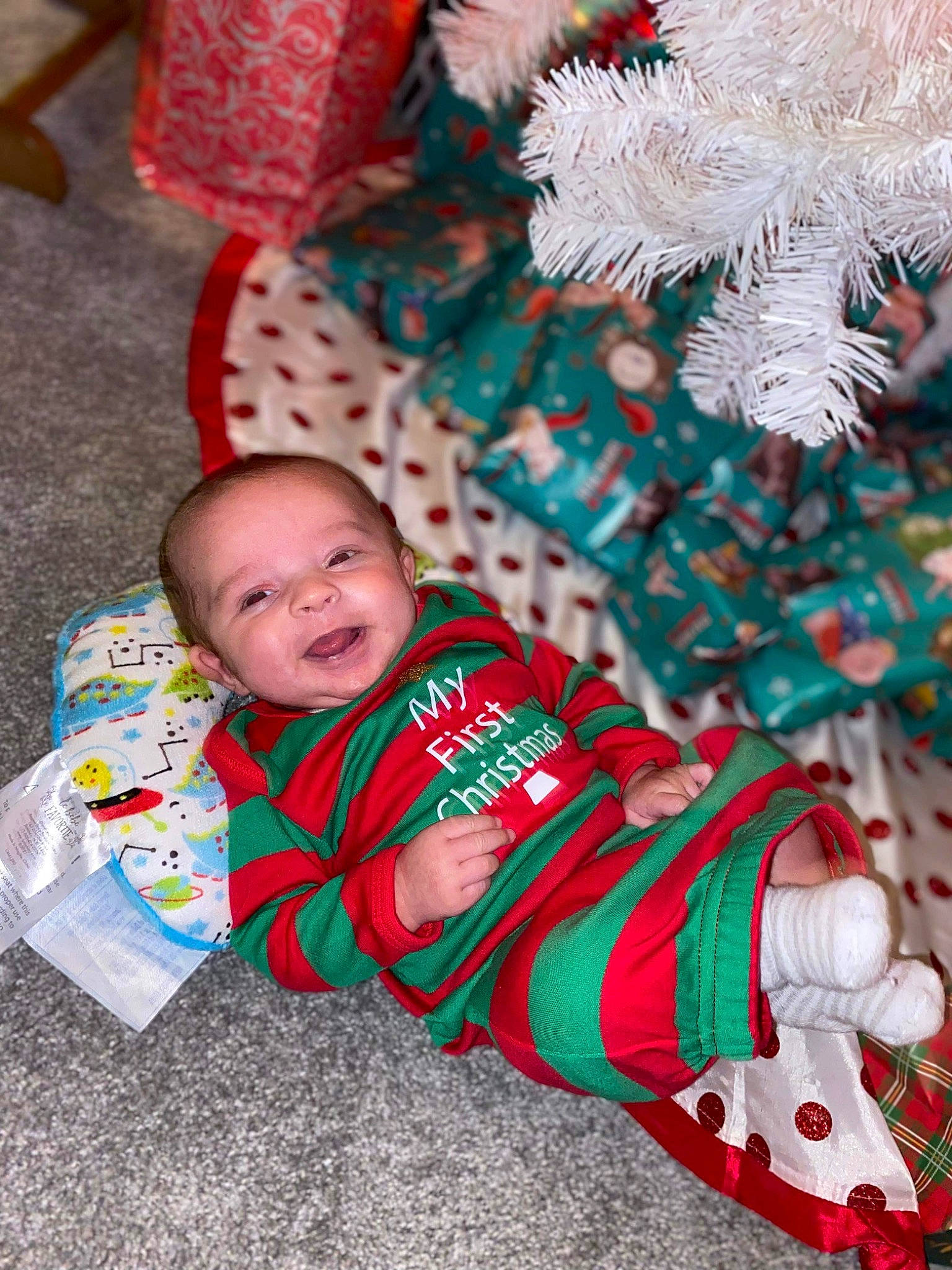 Kashton is registered to the contest to win money with this photo: baby, baby_toddler_clothing, child, christmas, christmas_decoration, christmas_eve, christmas_ornament, event, grass, happy, holiday, linens, mammal, ornament, pattern, person, sitting, smile, textile, toddler
