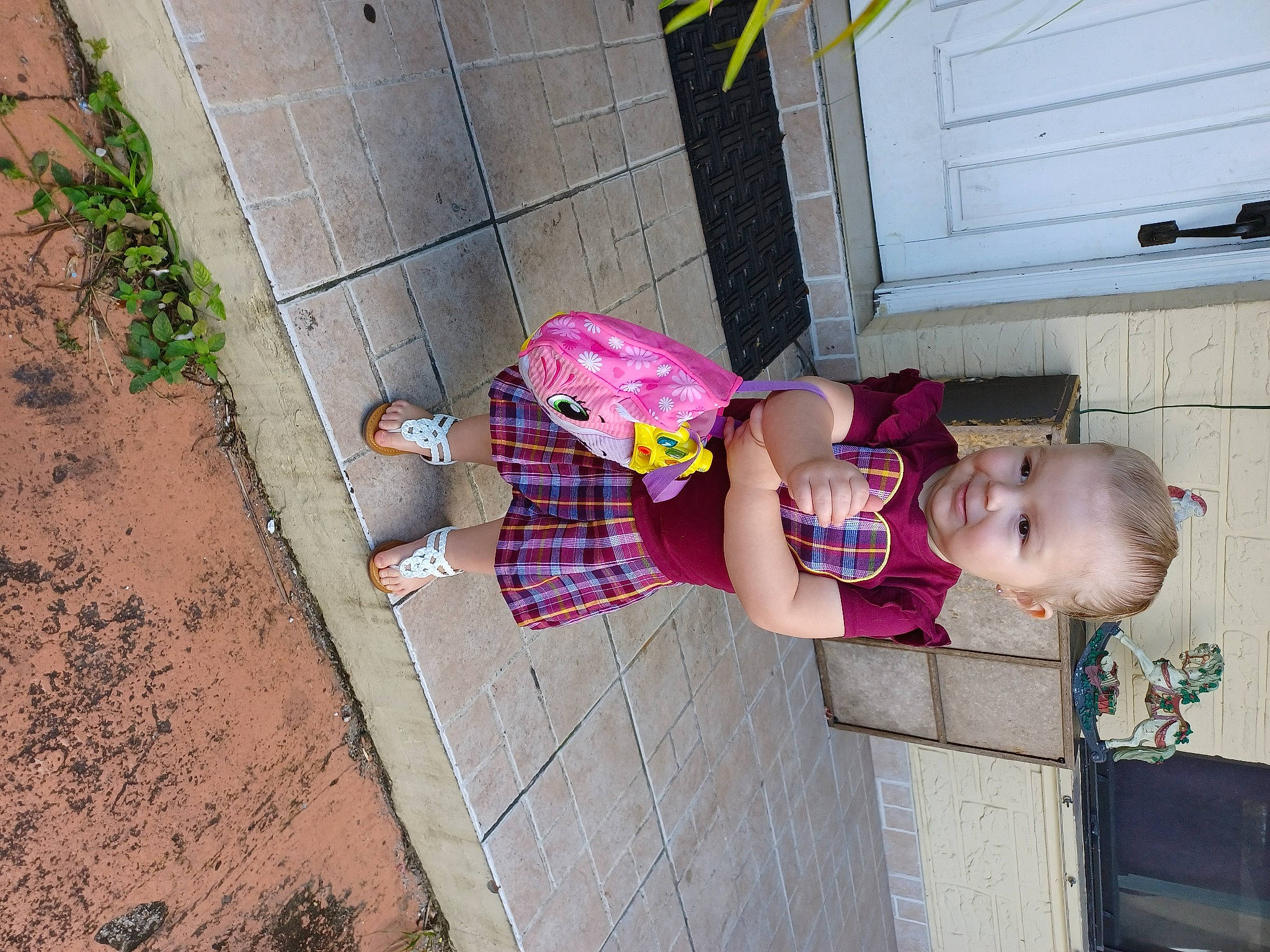 Makenzy is registered to the contest to win money with this photo: baby, baby_toddler_clothing, child, concrete, curb, door, flooring, fun, human_leg, leg, pattern, person, pink, plant, sandal, sidewalk, smile, thigh, toddler, vacation