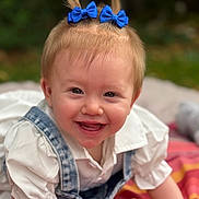 Camilia participe au concours pour gagner de l'argent avec cette photo : baby, child, smiling, blue_bows, denim_overalls, white_shirt, crawling, blanket, outdoor, grass, cute, happy, portrait, infant, face, fun, playful, young_child, person, head