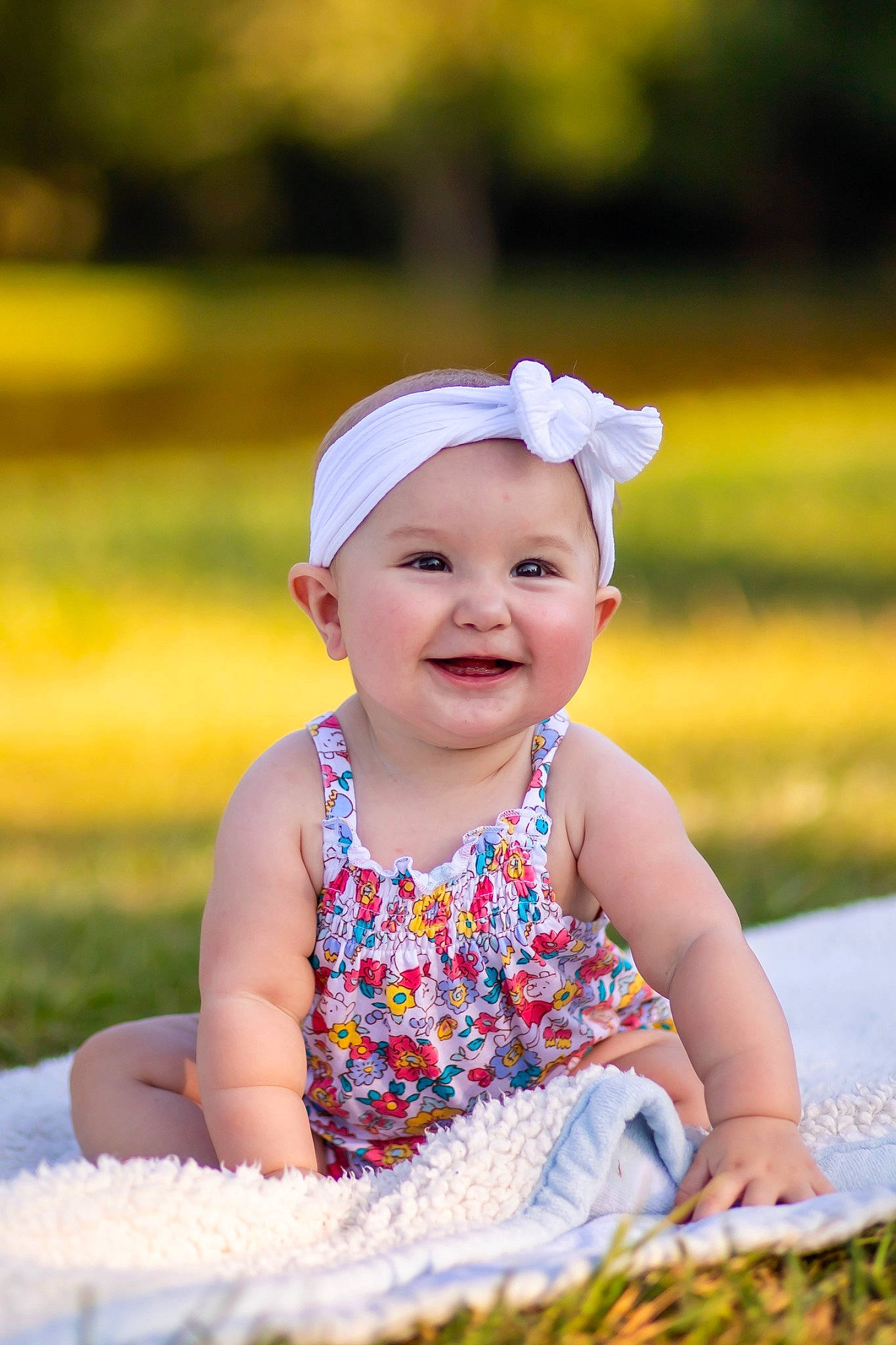 Mabel is registered to the contest to win money with this photo: baby, baby_toddler_clothing, beauty, child, eye, facial_expression, flash_photography, fun, grass, happy, headwear, joy, leisure, pattern, people_in_nature, person, sitting, skin, smile, spring