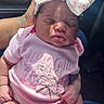 baby, sleeping, pink_clothing, bow, headwear, infant, hand, car_interior, sunlight, cute, newborn, soft_texture, socks, person, portrait, child, toddler, resting, clothing, accessory