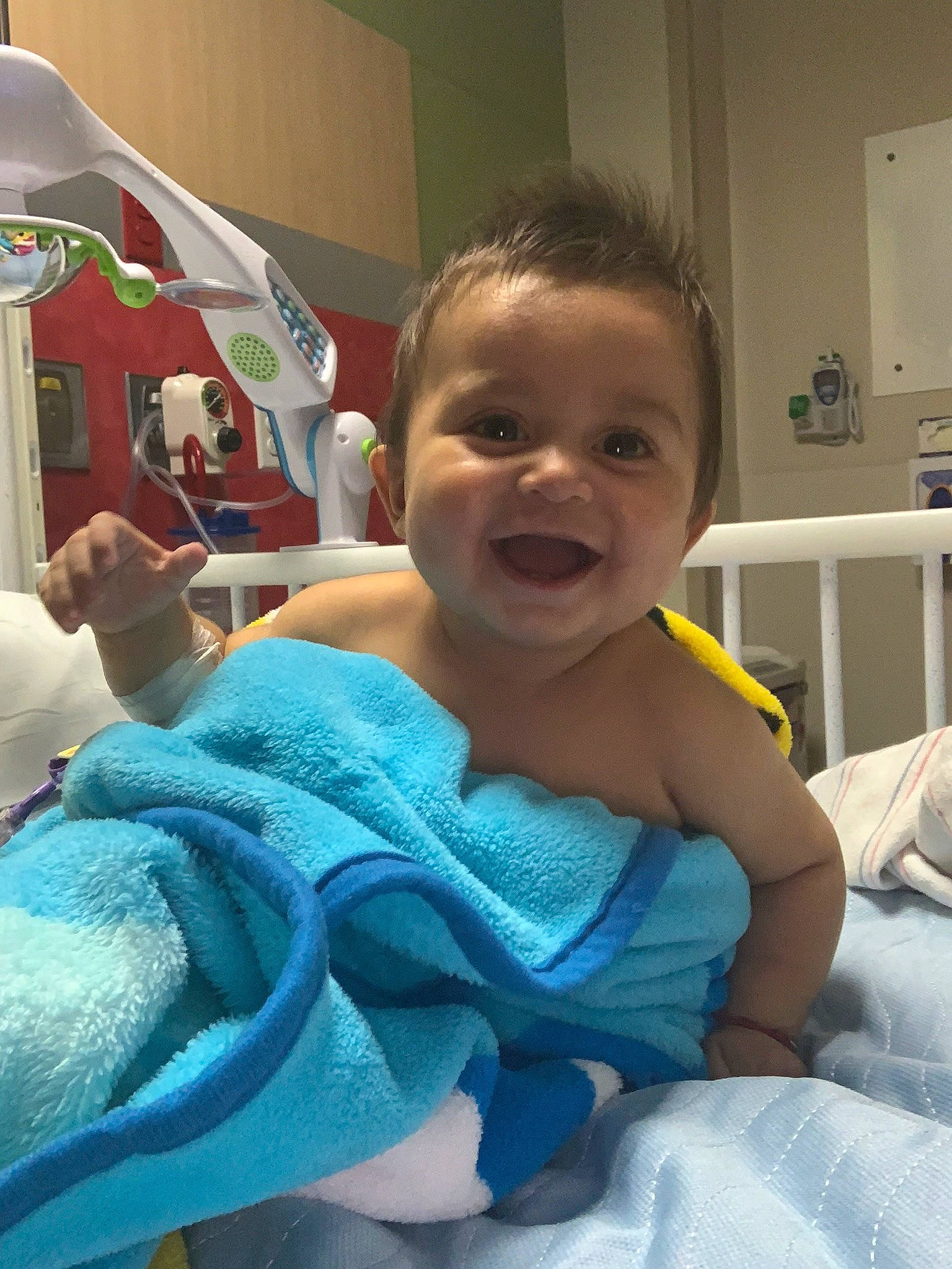 Aiden is registered to the contest to win money with this photo: baby, cheek, chest, child, comfort, event, finger, fun, happy, linens, mouth, person, room, sitting, skin, smile, thumb, toddler, tooth, vacation