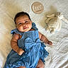 baby, infant, child, portrait, smiling, blue_outfit, dress, bow, blanket, plush_toy, bunny, nursery, lying_down, indoor, close_up, happy, face, wooden_sign, two_months, family_photo