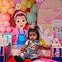 balloons, birthday, blue, cartoon, celebration, child, clothing, colorful, cute, decorations, event, gift_bags, indoor, party, pigtails, pink, playful, smiling, table, toddler