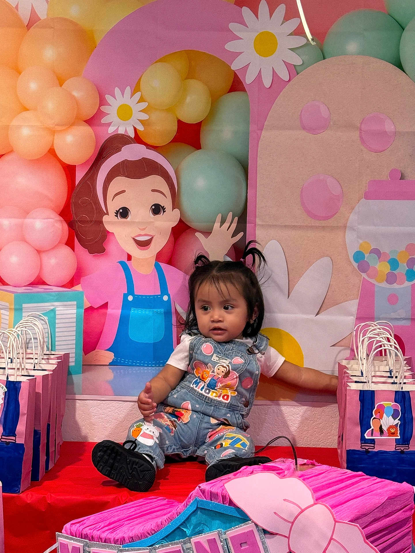 Milana is registered to the contest to win money with this photo: balloons, birthday, blue, cartoon, celebration, child, clothing, colorful, cute, decorations, event, gift_bags, indoor, party, pigtails, pink, playful, smiling, table, toddler