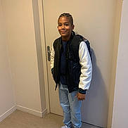 Bryan participe au concours pour gagner de l'argent avec cette photo : child, boy, standing, indoor, casual_clothing, backpack, sneakers, smiling, door, hallway, jacket, pants, person, hair_style, footwear, young, portrait, full_body, confident, light