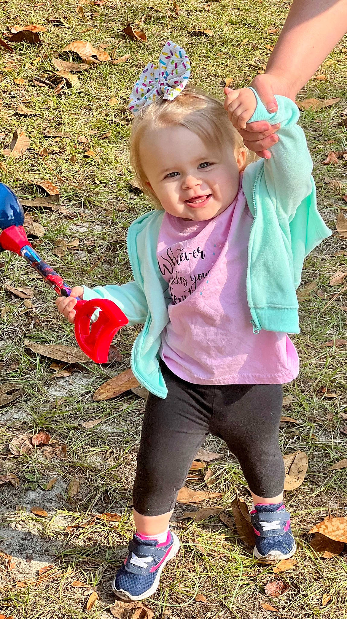 Kerrigan is registered to the contest to win money with this photo: baby_toddler_clothing, blue, botany, child, clothing, face, facial_expression, fun, gesture, grass, green, happy, head, leaf, people_in_nature, person, photograph, pink, plant, smile
