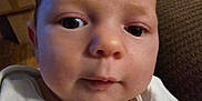 Hayden is registered to the contest to win money with this photo: baby, box, clothing, couch, cushion, face, frown, furniture, head, homedecor, indoors, linen, newborn, person, photography, portrait, sad, selfie, t_shirt, wood