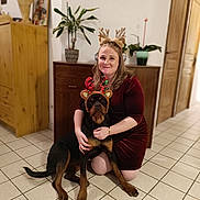 Aika participe au concours pour gagner de l'argent avec cette photo : antlers, christmas, cozy, decor, dog, festive, happy, holiday, home, indoor, kneeling, pet, plant, portrait, reindeer_ears, rottweiler, smiling, tile_floor, woman, wooden_furniture