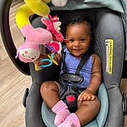 Hilani joined the competition — help win amazing prizes! baby, blue_outfit, car_seat, child, child_safety, cute, flooring, happy, indoor, infant, person, pink_socks, playing, plush_toy, portrait, safety_harness, seat, smiling, toy, wood_floor