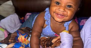 Hilani is registered to the contest to win money with this photo: baby, bed, blanket, blue, child, closeup, clothing, crawling, cute, happy, headboard, indoor, infant, person, pillow, playful, portrait, skin, smiling, toddler