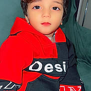 Aryan participe au concours pour gagner de l'argent avec cette photo : black_clothing, boy, casual, child, clothing, couch, expression, eyes, face, fashion, furniture, hair, hand, hoodie, indoor, person, portrait, red_clothing, sitting, young