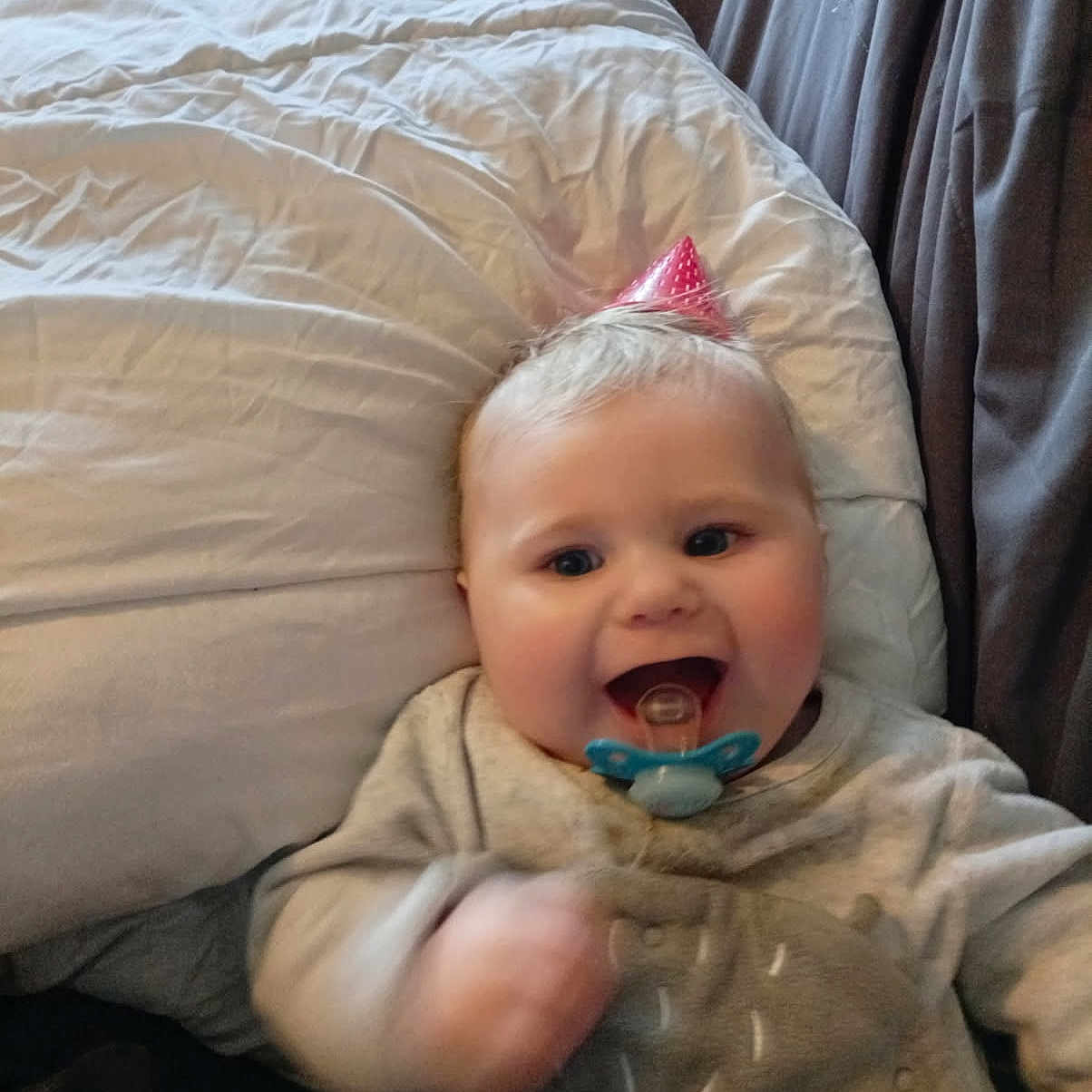 Liluo participe au concours pour gagner de l'argent avec cette photo : baby, bed, blanket, celebration, child, clothing, cozy, cute, face, happy, indoors, infant, lifestyle, motion_blur, pacifier, party_hat, person, pillow, smiling, soft_toys