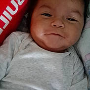 Mateo joined the competition — help win amazing prizes! baby, bedding, child, close_up, cute, face, gray_clothing, indoor, infant, lying_down, onesie, photography, pillow, portrait, red_background, serious_expression, sitting, sleepy, smiling, soft_lighting