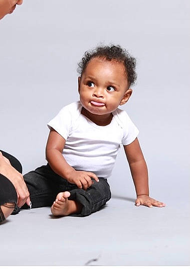 Kenzo is registered to the contest to win money with this photo: baby, baby_toddler_clothing, barefoot, cheek, child, comfort, elbow, fashion_design, flash_photography, flooring, gesture, happy, human_leg, knee, person, sitting, sleeve, smile, stock_photography, t_shirt