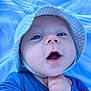 baby, blue_eyes, hat, blue_clothing, infant, close_up, face, cute, child, blanket, outdoor, expression, skin, person, newborn, portrait, hand, baby_gesture, headwear, young_child