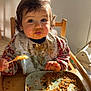 baby, bib, child, clothing, cute, dining, expression, face, feeding, food, hands, high_chair, indoor, meal, messy, plate, spoon, sunlight, toddler, wooden