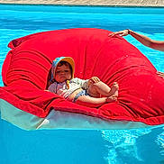 Marceau participe au concours pour gagner de l'argent avec cette photo : baby, beanbag, blue, child, floating, leisure, outdoor, person, pool, red, relaxing, smile, summer, sunglasses, sunhat, sunlight, swimming_pool, vacation, water, woman