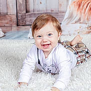 Soënn participe au concours pour gagner de l'argent avec cette photo : baby, child, smiling, happy, blue_eyes, white_shirt, plaid_pants, fluffy_rug, indoor, portrait, cute, crawling, face, person, soft_lighting, wood_background, flowers, cozy, toddler, clothing