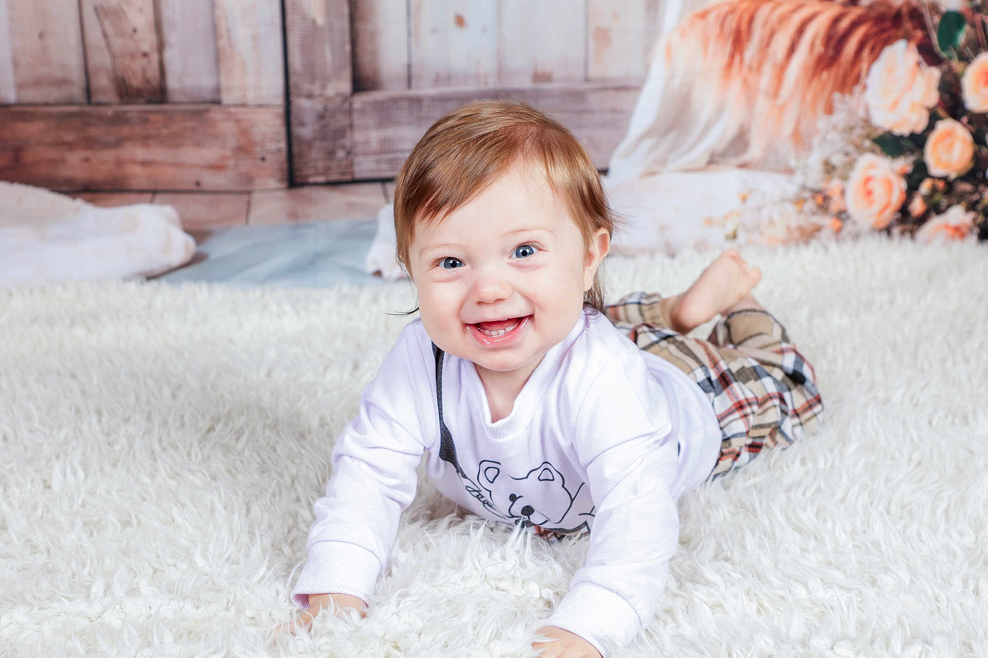 Soënn participe au concours pour gagner de l'argent avec cette photo : baby, child, smiling, happy, blue_eyes, white_shirt, plaid_pants, fluffy_rug, indoor, portrait, cute, crawling, face, person, soft_lighting, wood_background, flowers, cozy, toddler, clothing