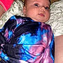 Kylynn is registered to the contest to win money with this photo: baby, infant, tie_dye_clothing, colorful, lying_down, blanket, carpet, sock, blue_eyes, close_up, soft_texture, casual, child, portrait, cute, indoor, person, young, head, face